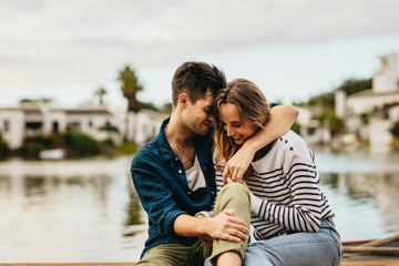 Couple in love sitting outdoors near a lake © Jacob Lund