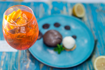 a glass with an orange drink and a chocolate cake