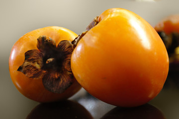 Two ripe yellow persimmon lying on the table