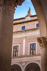 View of the court yard in the medieval Ducal Palace of Urbino  in Marche Italy with clock and old...