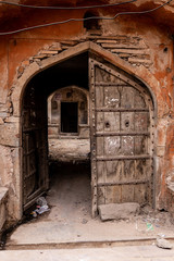 Old wooden door in arched pathway to Ganges river,