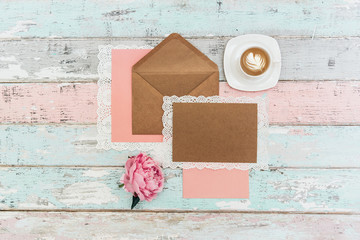 Mockup  greeting card, coffee and envelope with pink peonies on a vintage background