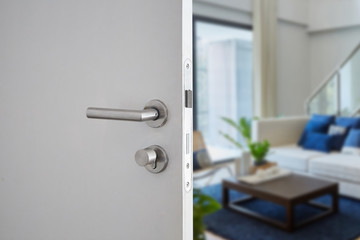 Door handle , door open in front of blur interior room background, selective focus - obrazy, fototapety, plakaty