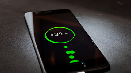 Teléfono celular cargándose y el display de pantalla iluminado