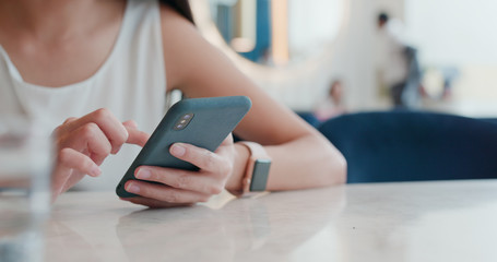 Woman use of mobile phone in coffee shop