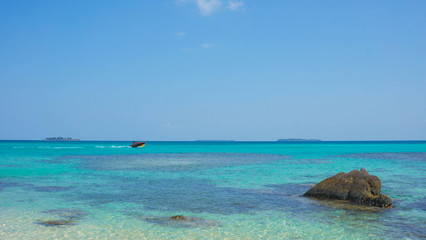 Fototapeta na wymiar stone water on the beach with very blue and clear sky on karimun jawa island