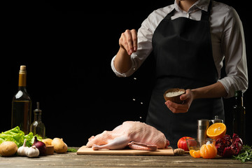 Cooking a festive duck for the Christmas, New Year's Eve dinner chef.Preparing fresh duck. Horizontal photo with dark black background.