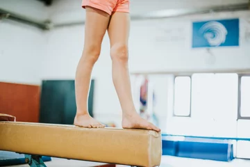 Zelfklevend Fotobehang Young gymnast balancing on a balance beam © Rawpixel.com