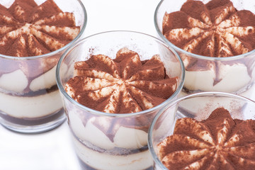 Sweet Italian dessert tiramasu with delicate mascarpone cream from traditional recipe in glass isolated on white background