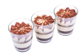 Sweet Italian dessert tiramasu with delicate mascarpone cream from traditional recipe in glass isolated on white background