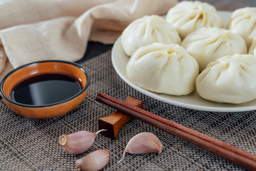 A plate of handmade steamed buns and a plate of vinegar from northern China	