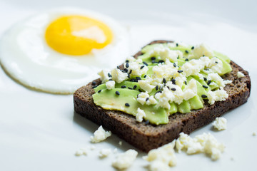 Avocado toast with sunny side up fried egg for breakfast