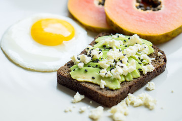 Avocado toast with sunny side up fried egg for breakfast