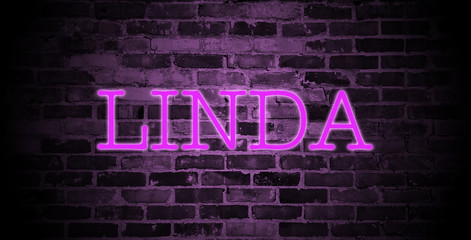 first name Linda in pink neon on brick wall