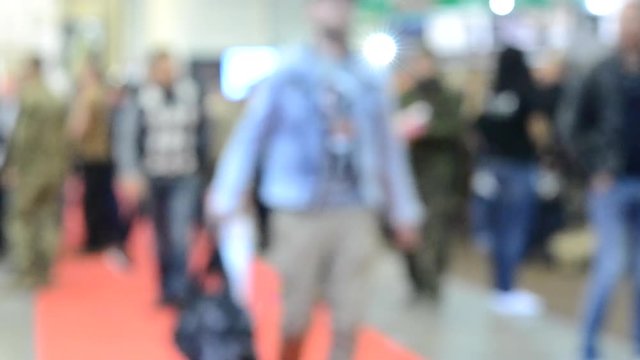 Many people walk inside the mall exhibition store. Blurred Background
