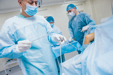 Arthroscope surgery. Orthopedic surgeons in teamwork in the operating room with modern arthroscopic...