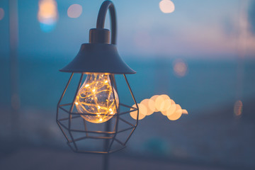 Vintage light bulbs decorated in the living room, sea view at sunset.