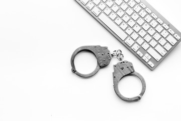Cyberfraud concept. Handcuff near keyboard on white background top view space for text
