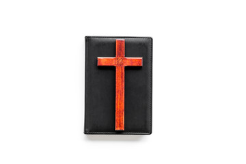 Farewell ceremony, funeral concept. Wooden cross on Bible on white background top view space for text