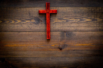 Funeral concept. Wooden cross on dark wooden background top view copy space