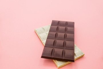 Chocolate bar with dried strawberry on a pink abstract background.