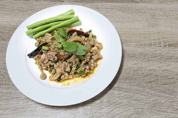 Spicy minced pork salad thai tradition food on wooden background with copy space
