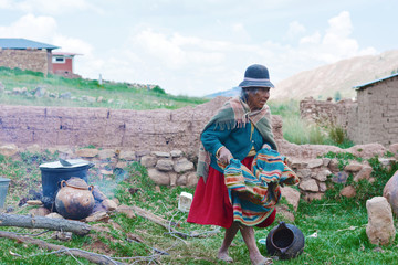 Old native american woman cooking outside.
