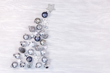 inclined christmas tree on white rustic background made from winter decorations