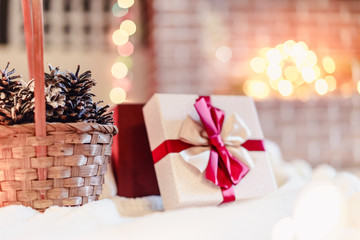 Wrapped gift with red ribbon on fireplace background