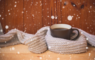 Christmas and winter time. Mug of hot coffee  wraped in scarf. View with copy space.