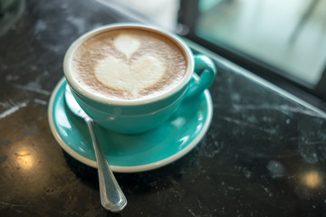 food background coffee cup with latte art placed on marble table by office in morning