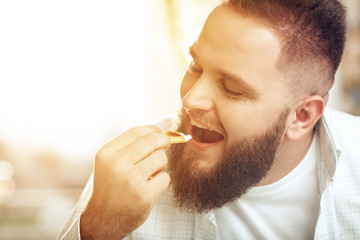 Portrait of man eating in cafe and enjoying food