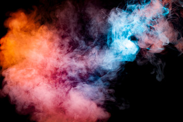 Fototapeta na wymiar A background of blue, red and orange wavy smoke in the shape of a ghost's head or a man of mystical appearance on a black isolated ground. Bright abstract pattern of steam from vape.
