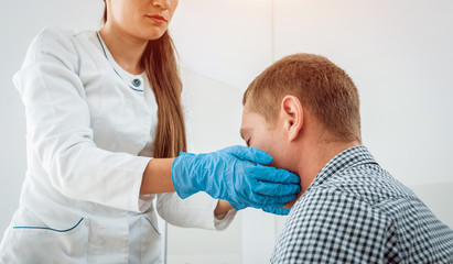 Otolaryngologist examines man's throat. Medical equipment
