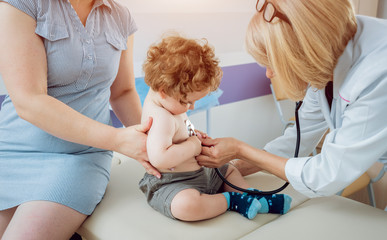 Friendly doctor pediatrician with patient child at clinic