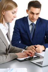 Obraz premium Business people using laptop pc while discussing project in office. Successful meeting and negotiation concepts