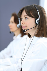 Call center. Group of operators at work. Focus on young brunette woman. Business  concept