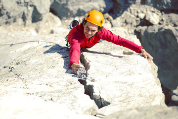 Climber in a helmet climbs up.