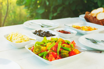 Colorful fresh organic vegetable salad on white table. Peppers, tomato cheese