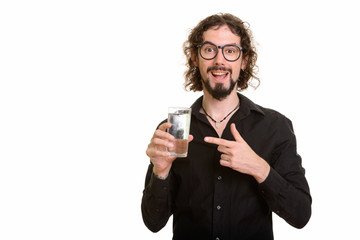 Happy handsome Caucasian man holding glass of water and pointing
