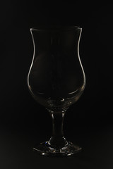 The contrast silhouette of a cocktail glass against dark background