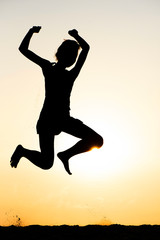 Fototapeta na wymiar Silhouette of Happy Woman and Fun Jumping on the Beach at the Day Time. Summer Time Vacation.