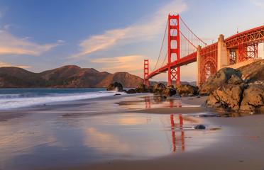 Golden Gate Bridge view from the hidden and secluded rocky Marshall's Beach at sunset in San Francisco, California