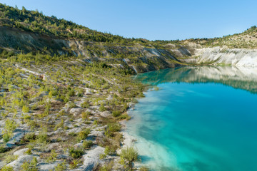 Fototapeta na wymiar Inactive gypsum quarry. In the quarry is a lake with blue water