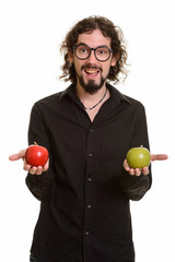 Happy handsome Caucasian man holding red and green apple