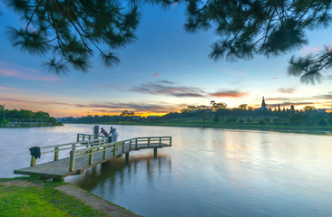 Fototapeta premium Sunrise on the small bridge overlooking the lake with the dramatic sky welcomes new day in the tourist city of Vietnam