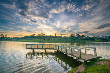 Sunrise on the small bridge overlooking the lake with the dramatic sky welcomes new day in the tourist city of Vietnam