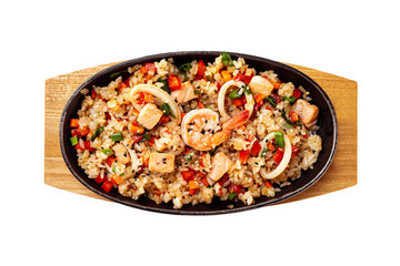 Top view pan of traditional Japanese rice with vegetables and seafood at wooden board isolated at white background.
