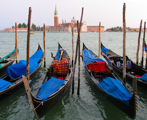 Fototapeta na wymiar Colorful gondolas in Venice, Italy frame the island of San Giorgio Maggiore
