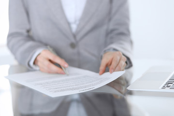 Close-up of female hands with pen over document,  business concept. Lawyer or business woman at work in office